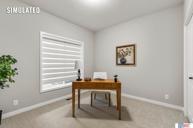 office area with a textured ceiling and light colored carpet