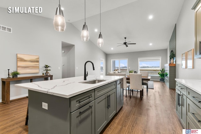 kitchen with hanging light fixtures, dishwasher, gray cabinets, sink, and a kitchen island with sink