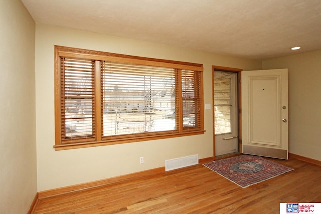 entrance foyer featuring baseboards, visible vents, and light wood-style floors