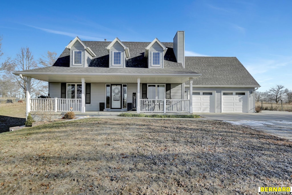 cape cod home with a garage and covered porch