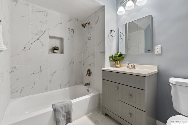 full bathroom featuring tiled shower / bath, vanity, and toilet