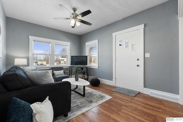 living room featuring ceiling fan, wood-type flooring, and a textured ceiling