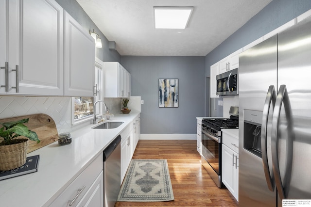 kitchen with white cabinetry, sink, backsplash, and appliances with stainless steel finishes