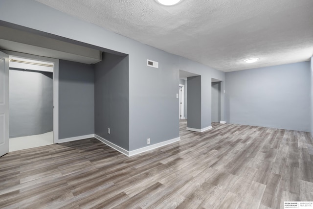 basement with wood-type flooring and a textured ceiling