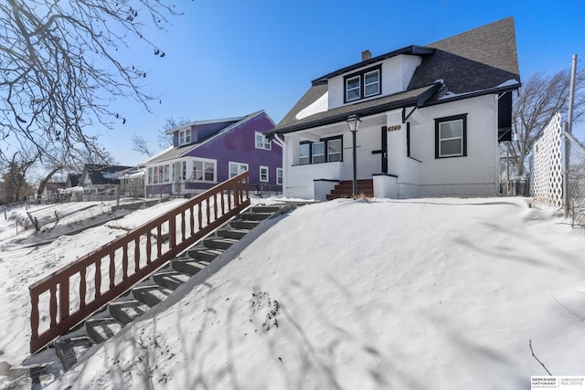 view of snow covered back of property