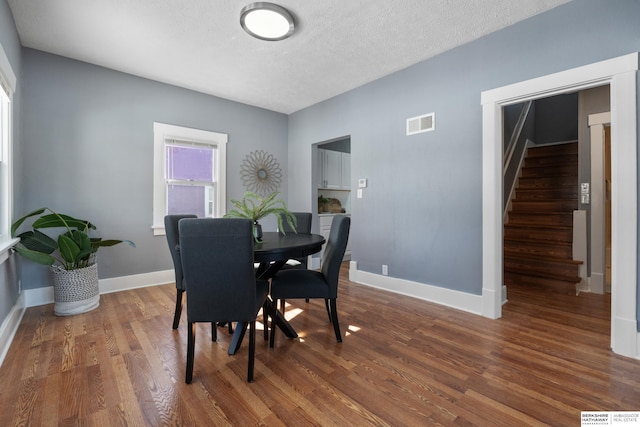 dining area featuring dark hardwood / wood-style floors and a textured ceiling