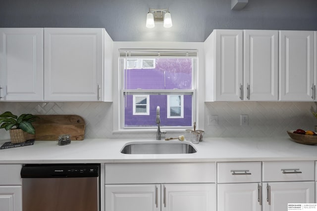 kitchen with sink, backsplash, stainless steel dishwasher, and white cabinets