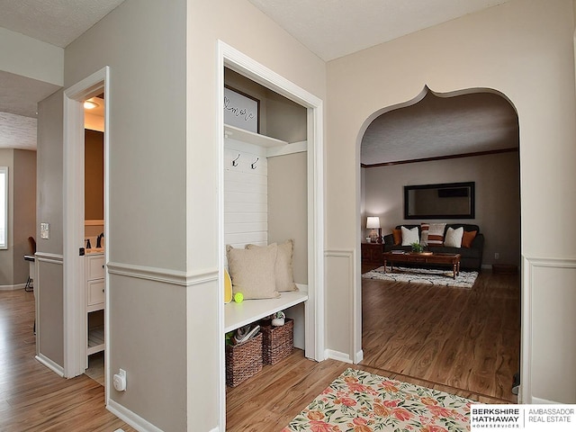 mudroom with light hardwood / wood-style floors and a textured ceiling