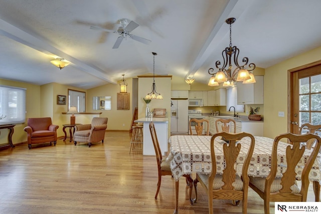 dining area featuring lofted ceiling with beams, sink, ceiling fan with notable chandelier, and light wood-type flooring