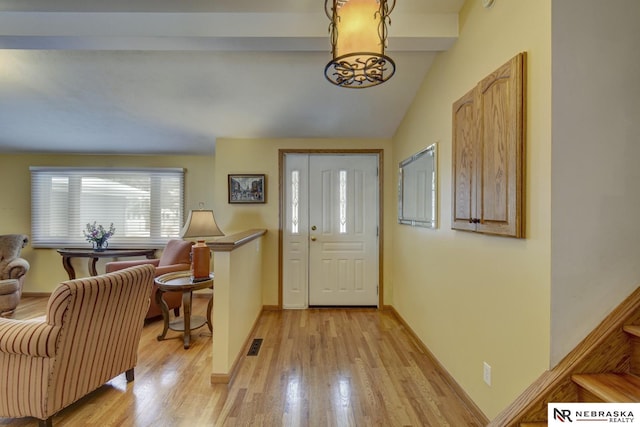 entryway featuring lofted ceiling and light hardwood / wood-style flooring