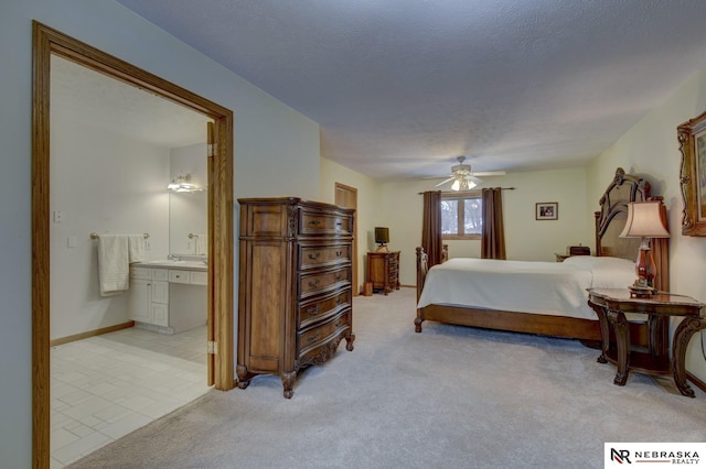 carpeted bedroom featuring ceiling fan, ensuite bathroom, and a textured ceiling