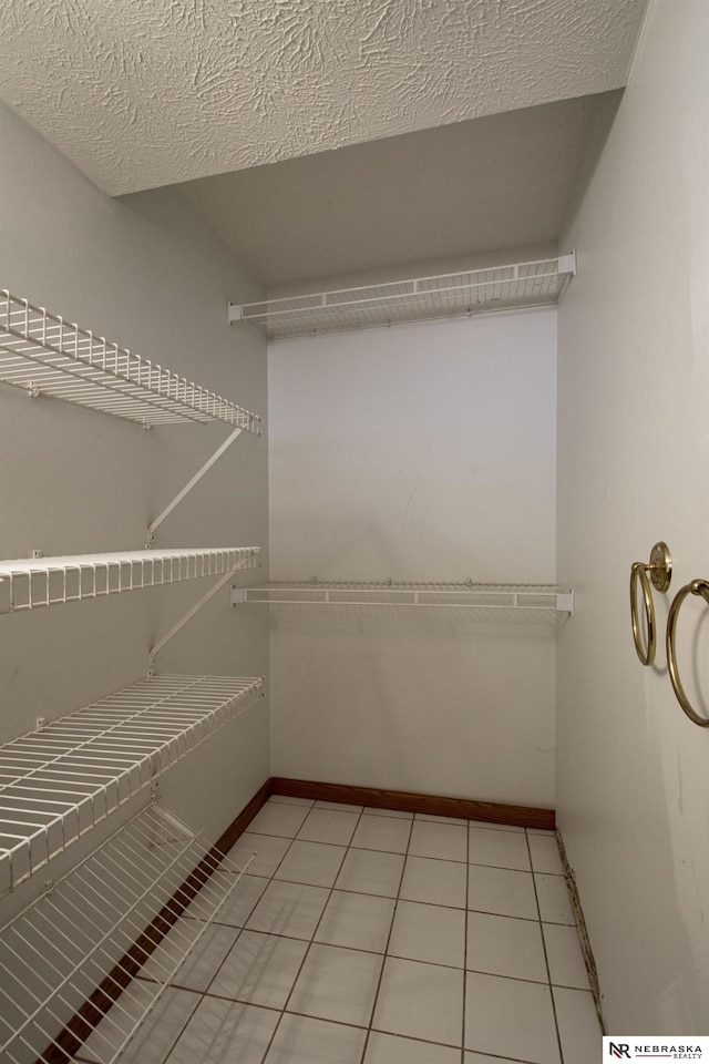 walk in closet with light tile patterned floors