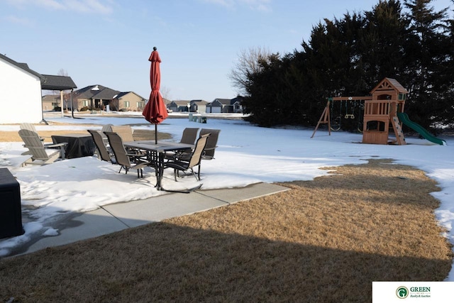 snow covered patio featuring a playground