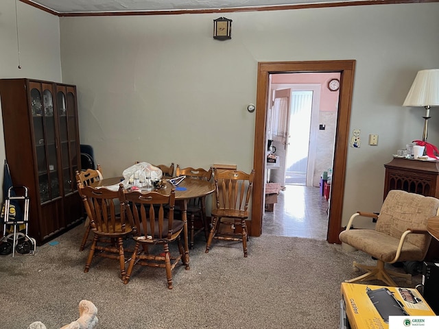 dining space with crown molding and carpet flooring