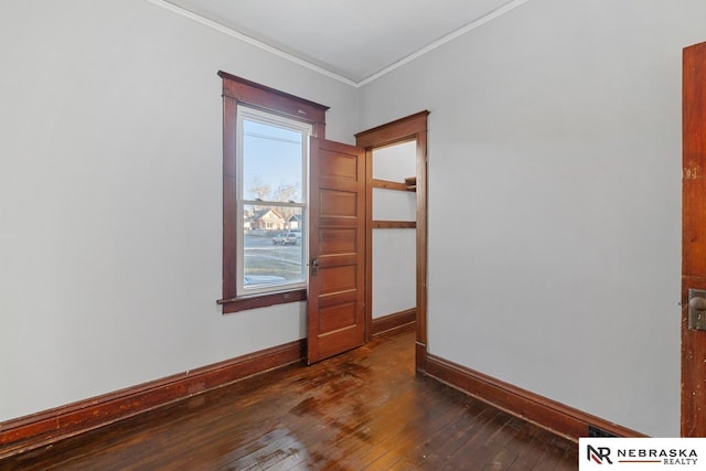 spare room with ornamental molding and dark hardwood / wood-style flooring