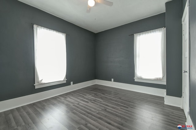 empty room with ceiling fan and dark hardwood / wood-style flooring