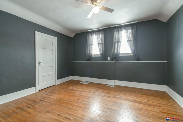 empty room featuring lofted ceiling, ceiling fan, and wood-type flooring