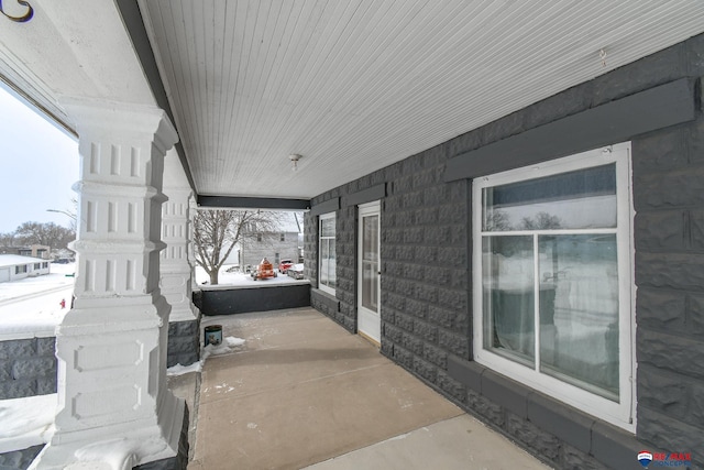 snow covered patio featuring covered porch