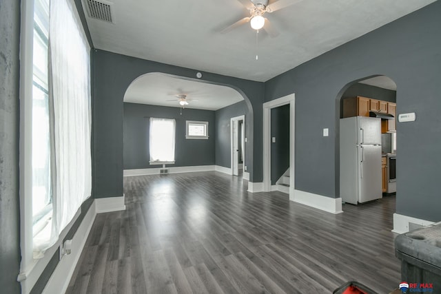 unfurnished living room with ceiling fan and dark wood-type flooring