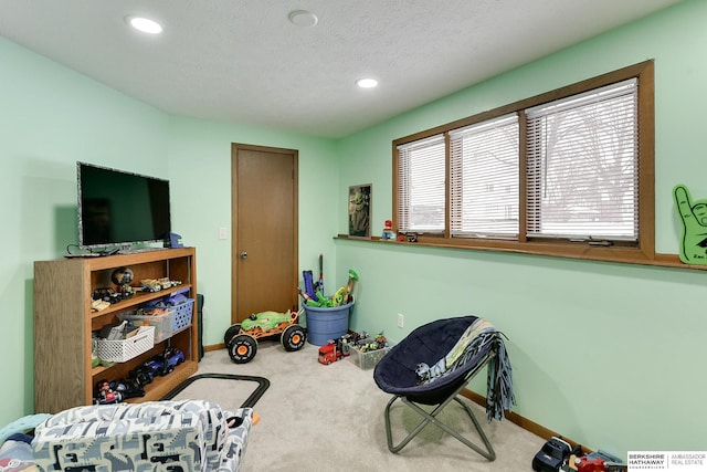 game room featuring carpet floors and a textured ceiling