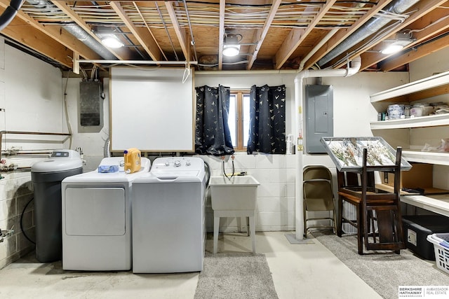 clothes washing area with sink, electric panel, and washing machine and dryer