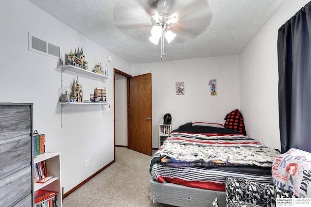 carpeted bedroom featuring ceiling fan and a textured ceiling