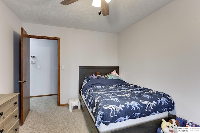 carpeted bedroom with ceiling fan and a textured ceiling