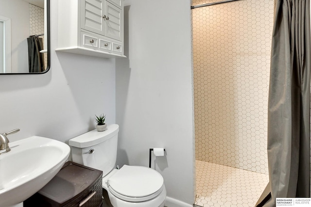 bathroom featuring sink, toilet, and a shower with shower curtain