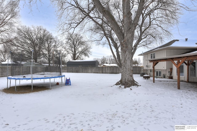 snowy yard with a trampoline