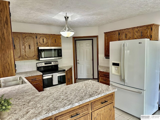 1815 Sherwood Cv, Fremont, NE 68025 - kitchen with light countertops, a textured ceiling, appliances with stainless steel finishes, and decorative backsplash
