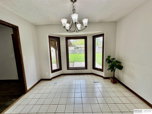 1815 Sherwood Cv, Fremont, NE 68025 - interior space featuring baseboards, a textured ceiling, light tile patterned floors, and a chandelier