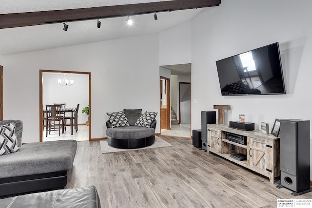 living room with lofted ceiling, an inviting chandelier, and light wood-type flooring