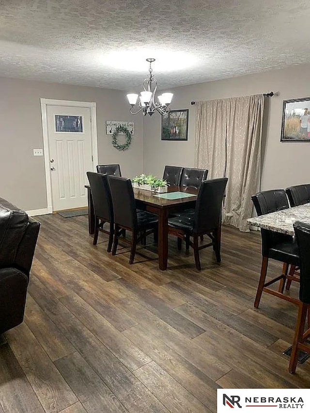 dining area with a chandelier, a textured ceiling, and dark hardwood / wood-style flooring