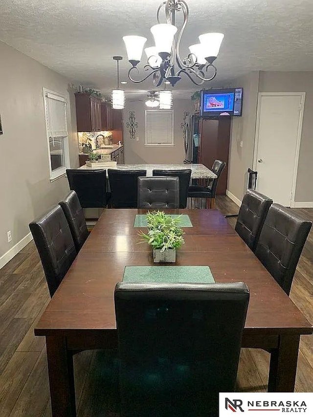 dining area featuring an inviting chandelier, hardwood / wood-style floors, and a textured ceiling