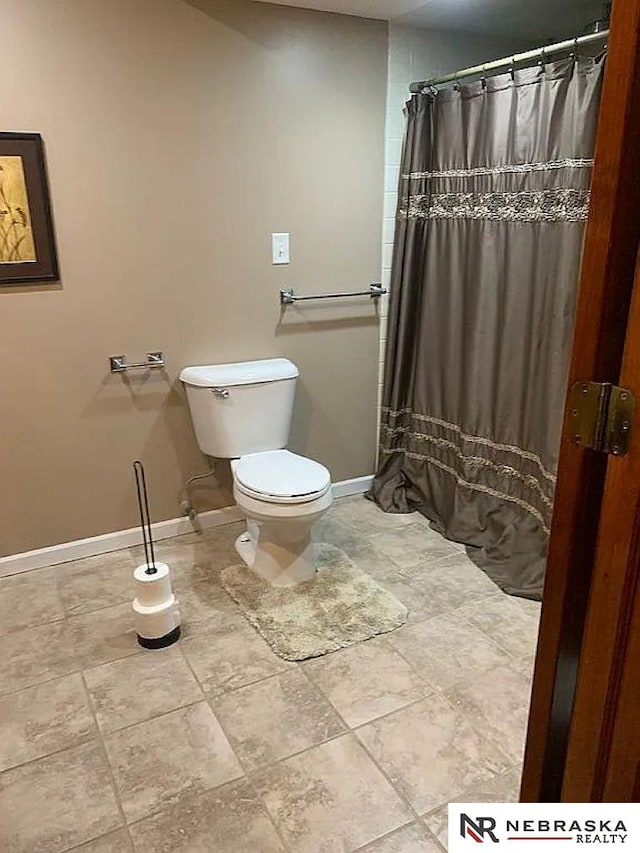 bathroom featuring a shower with curtain and toilet