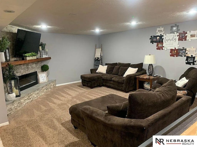 carpeted living room with a stone fireplace