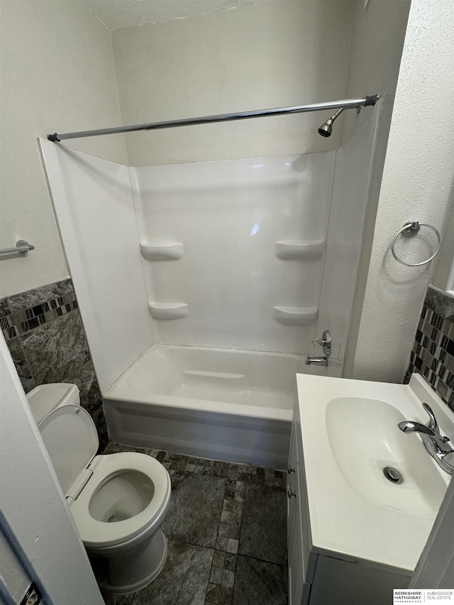 bathroom featuring bathtub / shower combination, vanity, and toilet