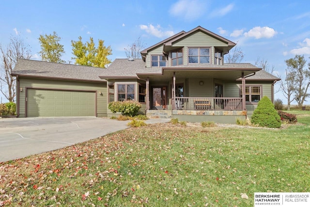 view of front facade featuring a garage, a front yard, and covered porch