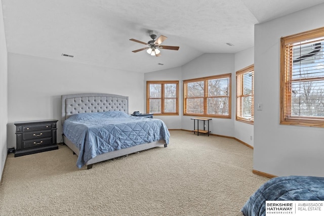 bedroom featuring ceiling fan, vaulted ceiling, carpet, and a textured ceiling