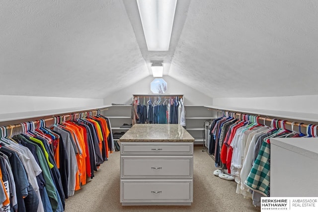 walk in closet with light carpet and lofted ceiling