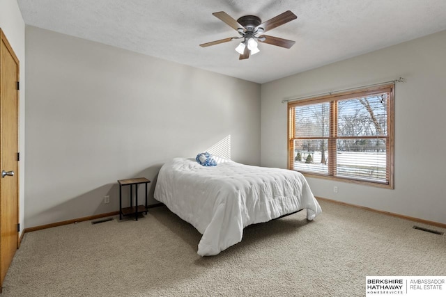 bedroom featuring ceiling fan, carpet flooring, and a textured ceiling