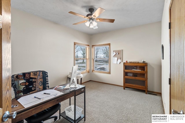 carpeted office featuring a textured ceiling and ceiling fan