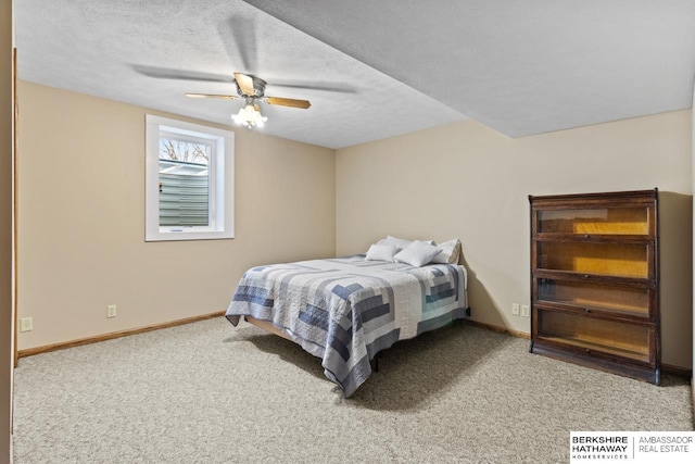 carpeted bedroom with ceiling fan and a textured ceiling