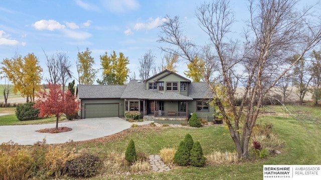 view of front facade featuring a porch, a garage, and a front yard