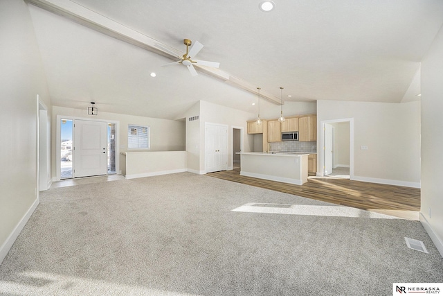 unfurnished living room with vaulted ceiling, ceiling fan, and carpet flooring