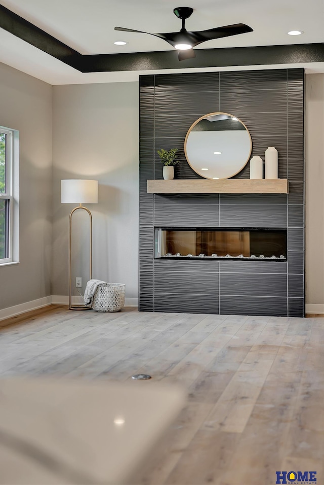 interior space featuring ceiling fan, a fireplace, and hardwood / wood-style floors