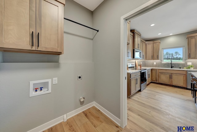 laundry room featuring sink, washer hookup, hookup for an electric dryer, and light hardwood / wood-style floors