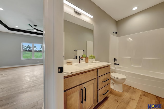 full bathroom with toilet, wood-type flooring, tub / shower combination, vanity, and ceiling fan