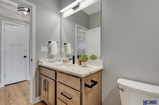 bathroom featuring vanity, hardwood / wood-style flooring, and toilet