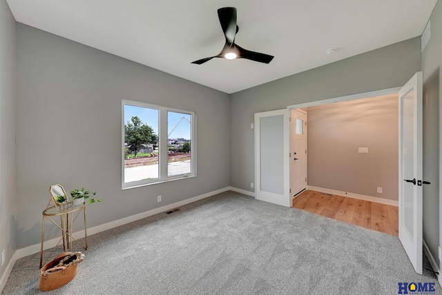 unfurnished bedroom with french doors, ceiling fan, and light carpet